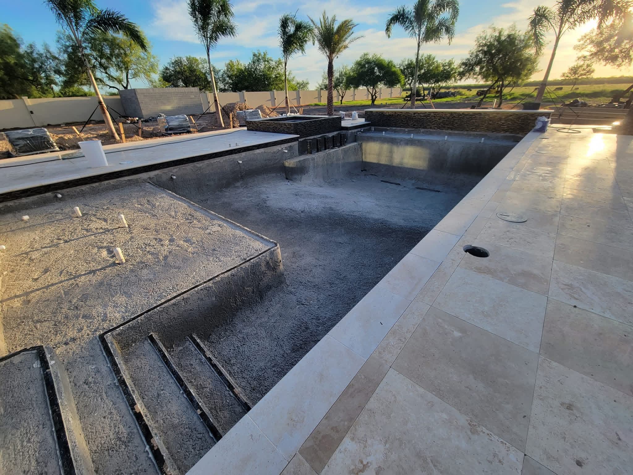 Completed pool shell with travertine decking, ready to fill