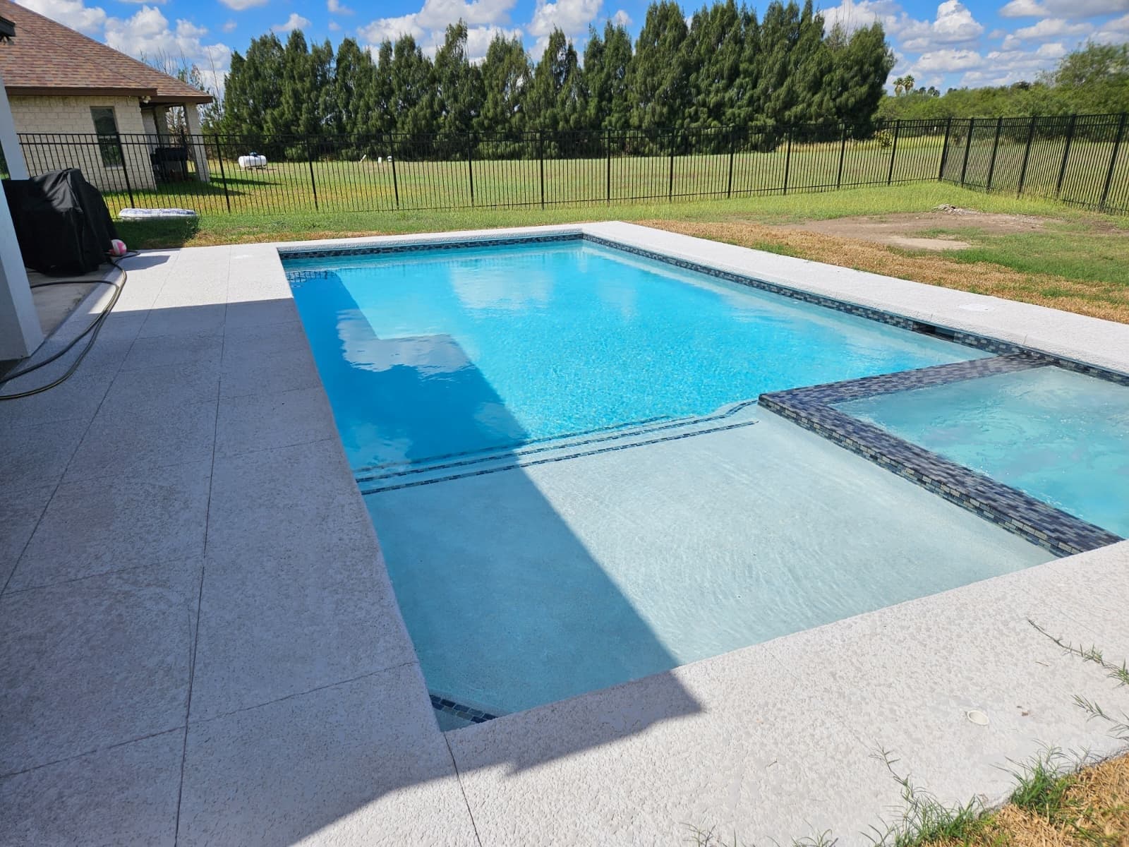 Sparkling backyard pool and spa maintained by Garma Pools