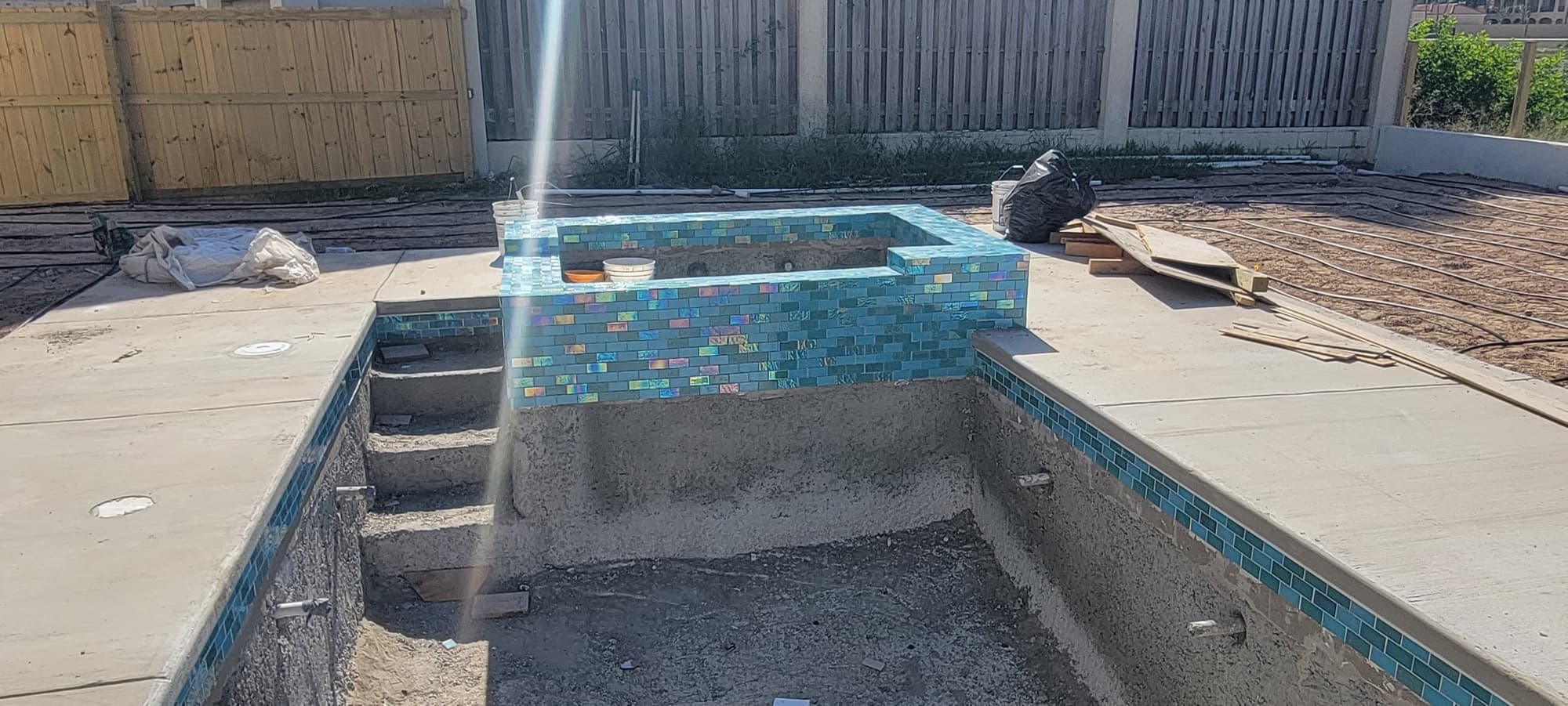 Waterline tile being installed around the pool and spa