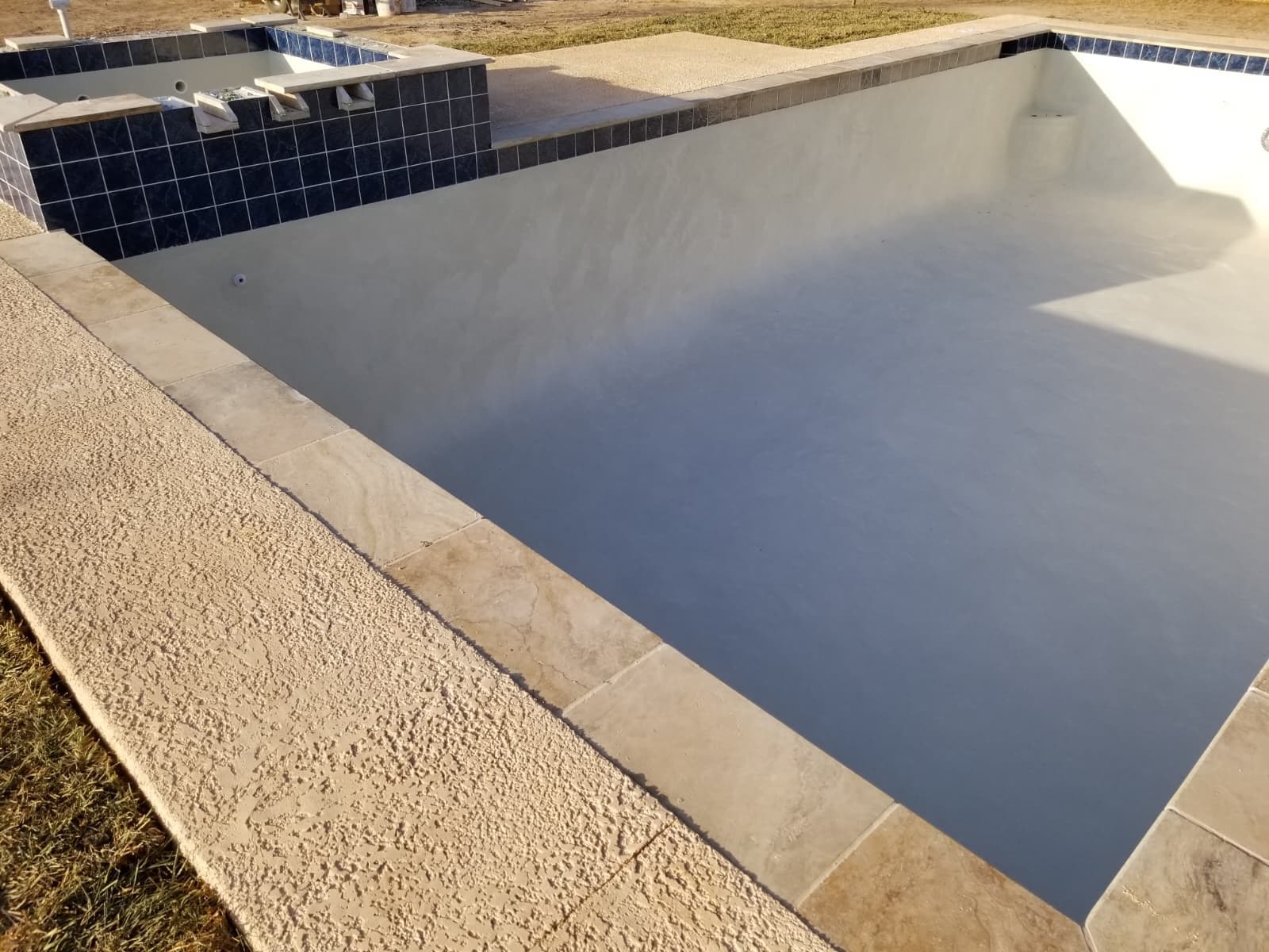 Freshly plastered pool shell with steps, ready for water